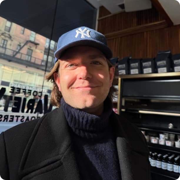 Devyn Lowry smiling inside a coffee shop, wearing a Yankees cap