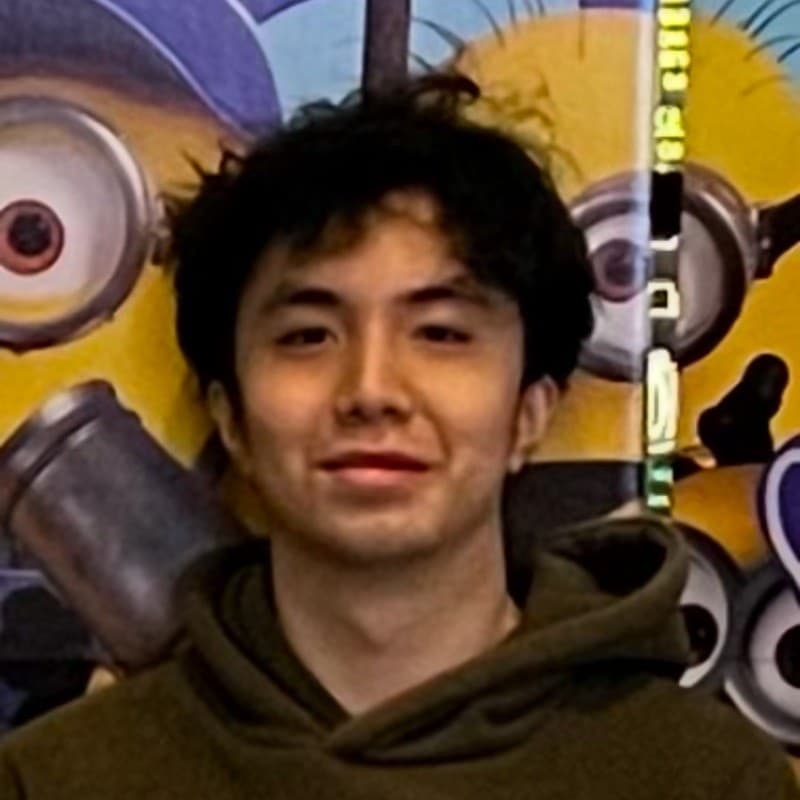 Kevin Vu smiling in front of a Minions mural